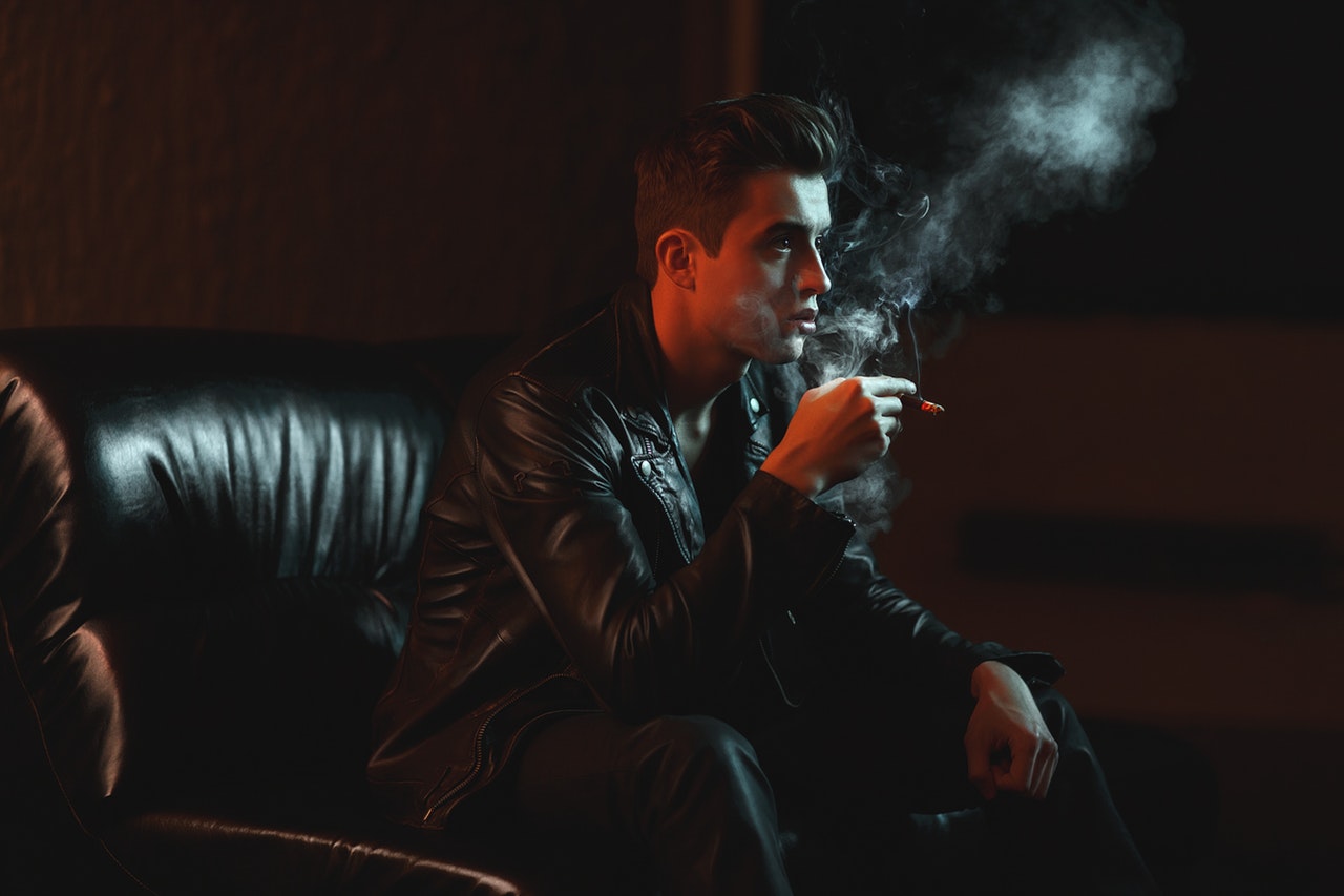 a man in black clothes smoking