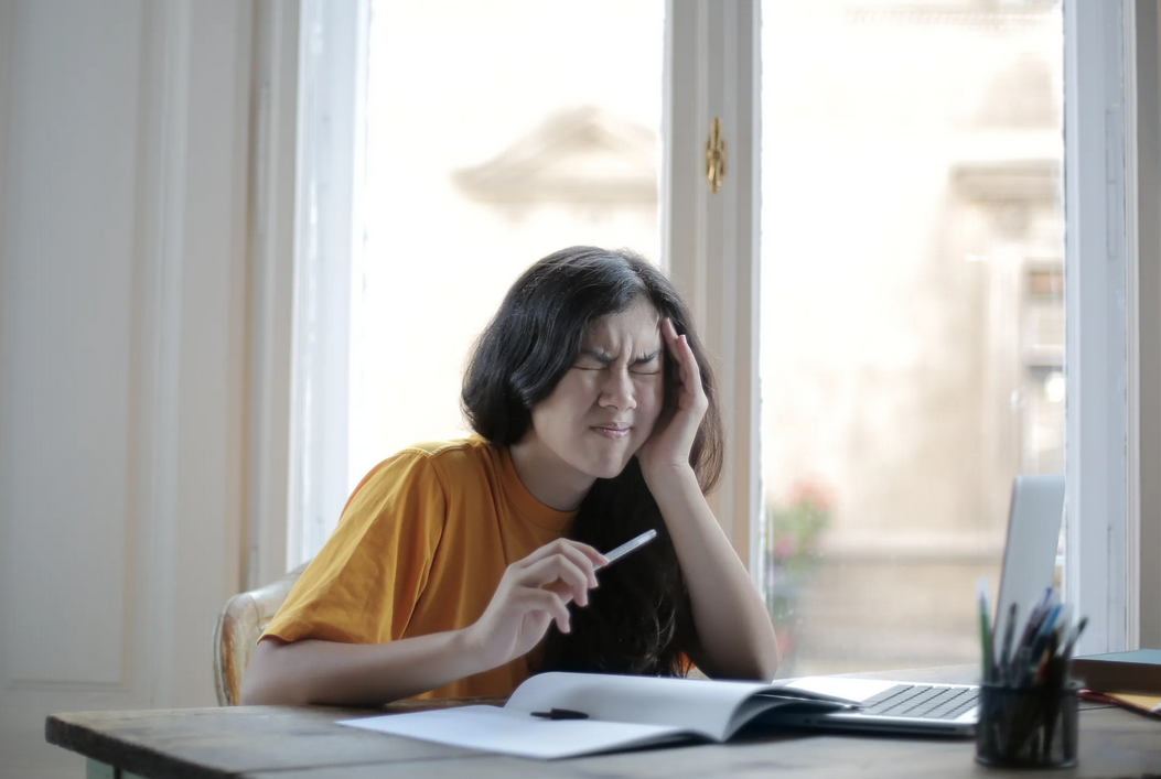 sitted woman touching her head